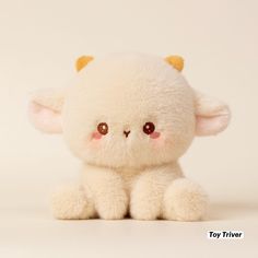 a small white stuffed animal sitting on top of a table