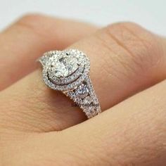 a woman's hand with a diamond engagement ring on top of her finger,