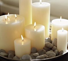 several lit candles sitting on top of rocks