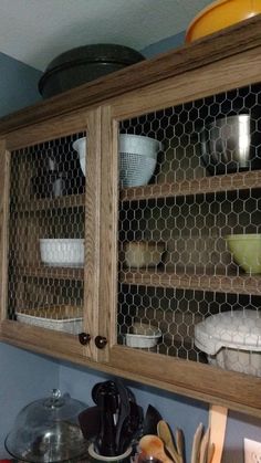 the chicken wire is hanging on the wall above the kitchen cabinet doors, which are open