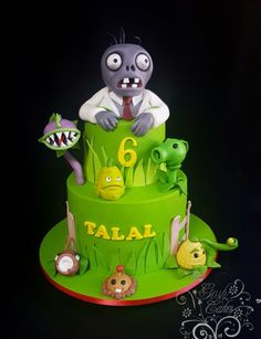 a green cake decorated with cartoon characters on it