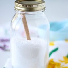 a glass jar filled with sugar and a wooden spoon