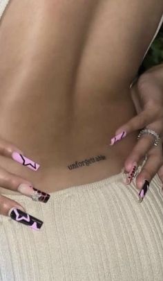 a woman with pink and black nail polish on her stomach, holding onto the side of her body