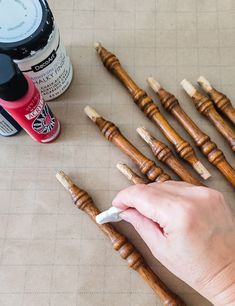 someone is making wooden dowels out of wood and paint them with white chalks