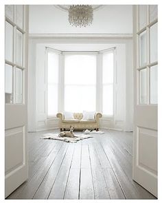 an empty room with white walls and wooden floors