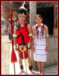 two people standing next to each other in native american clothing and headdress,