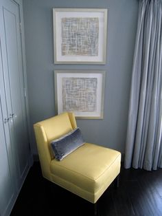 a yellow chair sitting in front of two pictures on the wall next to a window