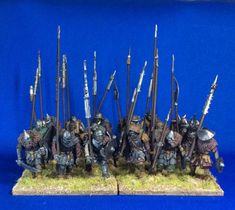 a group of warhammers with spears and shields on their heads standing in front of a blue background