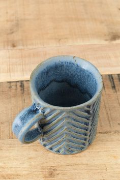 a blue cup sitting on top of a wooden table