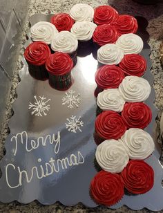 a cake shaped like the letter f with red and white cupcakes