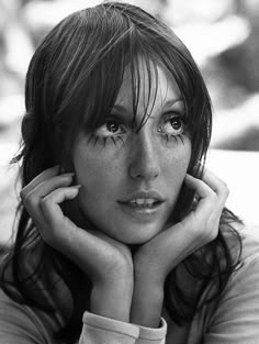 a black and white photo of a woman with freckles on her face looking at the camera