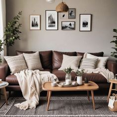 a living room with brown leather couches and pictures on the wall above them, along with potted plants