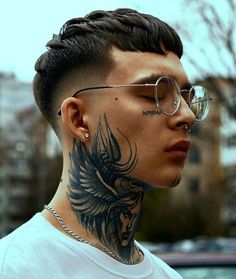 a man with glasses and a tattoo on his neck