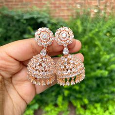 Rose Gold CZ Chandelier Earrings.  Earrings Length- 2.4 inches Earrings Width- 1 inches Weight of the earring- 19 gram per earring Add a touch of elegance and sophistication to your jewelry collection with our Rose Gold CZ Jhumka Earrings. Expertly crafted to blend traditional charm with contemporary flair, these exquisite earrings are a perfect choice for those seeking to enhance their look with a touch of luxury. **Design These jhumka earrings feature a stunning rose gold finish that adds a wa Rose Gold Drop Earrings For Festive Occasions, Traditional Rose Gold Earrings For Celebration, Rose Gold Earrings For Wedding And Festive Occasions, Festive Rose Gold Earrings For Gift, Festive Rose Gold Wedding Earrings, Indian Earrings Jhumka, Earrings Jhumka, Gold Jhumka, Jhumka Designs