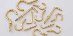 brass plated screws and nails are laid out on a white surface