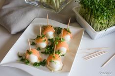 small appetizers are arranged on a plate with toothpicks in the middle