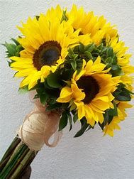 a bouquet of sunflowers in someone's hand with the string wrapped around it