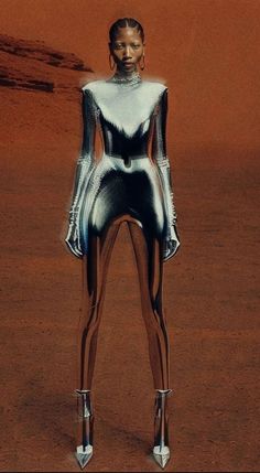 a futuristic woman standing in the middle of a desert