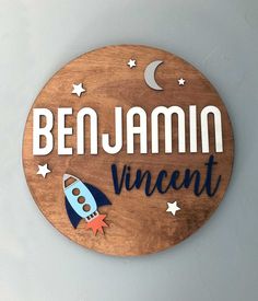 a wooden sign that says benjamin innocent with a rocket ship on the bottom