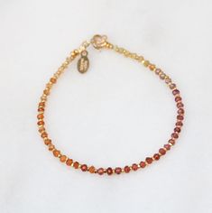 A stunning bracelet in a rainbow ombre of tundra sapphire gemstones in sunset shades of red, orange, pink and yellow separated by sparkling little gold nuggets in Karen Hill Tribe gold vermeil, finished with a 14 carat gold-filled spring ring clasp. This bracelet can also be made in sterling silver or 14k rose gold fill, please select your finish during checkout. I make each piece of Salt Bijoux jewellery using the finest quality natural gemstones so each accessory is truly unique and one of a k Multicolor Faceted Spiritual Bracelets, Elegant Rainbow Faceted Jewelry, Adjustable Rainbow Jewelry With Faceted Beads, Elegant Adjustable Rainbow Beaded Bracelets, Multicolor Faceted Rondelle Bracelets, Elegant Rainbow Jewelry With Faceted Beads, Rainbow Bracelet For Jewelry Making, Rainbow Hand-strung Round Jewelry, Rainbow Hand-strung Jewelry Gift