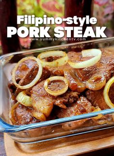 a glass casserole dish filled with pork steak and onions, sitting on a wooden cutting board