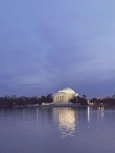 the jefferson memorial in washington d c at night with reflections on the water and trees around it