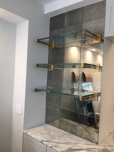 a bathroom with marble counter tops and shelves