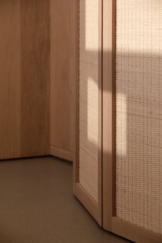 the corner of a room with wood and white wicker covering it's walls