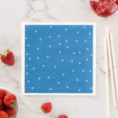 strawberries and ice cream on a marble table with blue paper, two strawberries and one strawberry