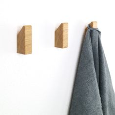 two wooden pegs are hanging on the wall next to a towel and coat rack