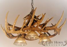 a chandelier made out of antlers with bells hanging from the bottom and two lights on each side