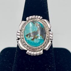 Stunning oval vintage Navajo ring. This spectacular ring is marked 925 sterling silver with a radiant turquoise stone!  The inlay is set in a twisted silver flower shape setting.  The stone inlay is about 3/4" long and about 1/4" across, size approximately 8.5.  This gem has beautiful detailing and a sturdy well designed band.  Such a gorgeous piece to accent any attire casual or dressy! SKU 25794 Silver Oval Turquoise Ring With Concho Detail, Silver Oval Turquoise Ring With Concho, Western Oval Turquoise Ring With Concho, Western Style Oval Turquoise Concho Ring, Western Style Oval Turquoise Ring With Concho, Oval Western Turquoise Ring With Concho, Southwestern Oval Turquoise Ring Stamped 925, Navajo Ring, Navajo Style