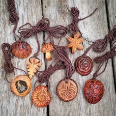 various wooden ornaments are laid out on a wood surface with string and beads attached to them