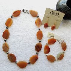 New Genuine Rust Colored Stone Jewelry Set-Includes Necklace, Bracelet, And Earring. Beautifully Smoothed And Polished Stone With Large Sterling Silver Balls Separating Each Oval Shaped Stone. Earrings Hang About 1.5in. Necklace Measures 20in With Toggle Closure. Bracelet Is 8.5in, With Toggle Closure. Hardware On All Is Sterling Silver. Believe Stone Is Orange Agate Or Banded Carnelian. Timeless And Gorgeous Set From Quality Brand-Dillard's. Sure To Get Lots Of Compliments!!New Still With Tags. Banded Carnelian, Heart Pendant Necklace Silver, Coin Pearl Earrings, Color Stones Jewelry, Long Statement Necklace, Orange Agate, Oval Necklace, Coin Pearls, Colored Stone