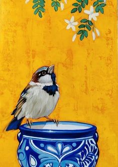 a painting of a bird sitting on top of a blue and white bowl with flowers in the background