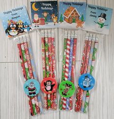 six christmas themed pencils in cellophane bags on a white wooden table with greeting cards