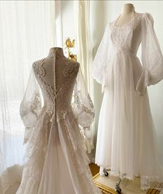 two wedding gowns on display in front of a window