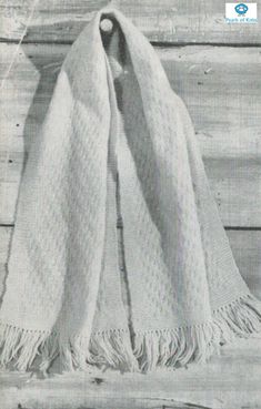 an old photo of a white scarf hanging on a wooden wall