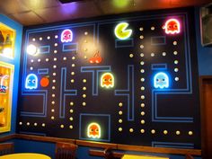 a room with neon lights and pacman game on the wall