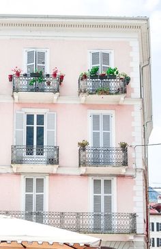 an apartment building with balconies and flower boxes on the balconys in front of it