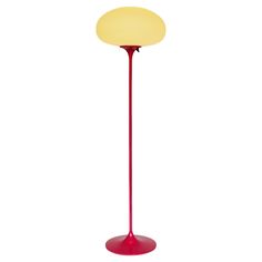 a red floor lamp with a yellow light on it's base and a white background