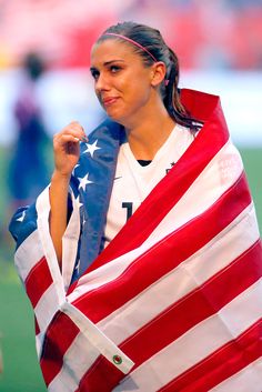 a female soccer player holding an american flag