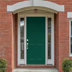 a green front door on a brick building