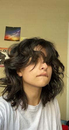 a woman with her hair blowing in the wind and looking up at something on top of her head