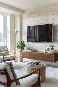 a living room with a large flat screen tv mounted on the wall next to a window