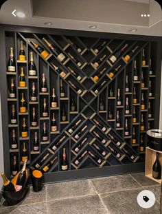 a wine rack with many bottles on it in the middle of a room next to a wall