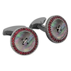 Precious Button Cufflinks with Black Mother of Pearl & Rubies A luxurious reinvention of the classic tailoring button. This button is meticulously crafted from three materials, silver, semi-precious stone and precious rubies or sapphires. The semi-precious stone follows shape of a button and even has a grooved channel line carved into it; the centre has a raised silver wire just like that of a button. The outer frame of the cufflink has skilfully set rubies or sapphires, both are precious stones Black Rhodium, Mother Pearl, Silver Wire, Rhodium Plated, Semiprecious Stones, Precious Stones, Mother Of Pearl, Semi Precious, Cufflinks