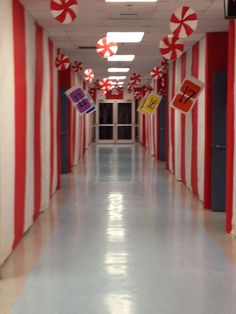 the hallway is decorated with red and white striped walls, candy canes hanging from the ceiling