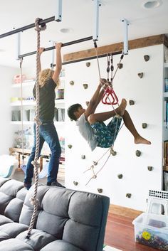 two people hanging from ropes in a living room