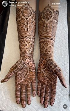 two hands with henna designs on them, one showing the intricate pattern and the other showing